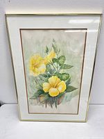 Frontal view of framed watercolour painting showing yellow hibiscus flowers with signature visible at bottom right.