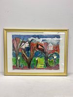 Framed watercolor painting showing abstract colorful trees and landscape, signed by artist.
