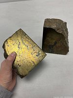 Both pyrite rock bookends with one showing natural rough surface and the other showing polished golden face.