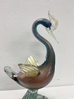 Front view of Murano figural bird glass statue showing lilac body, gold aventurine wings and clear base.