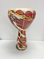 Front view of the vintage Tunisian enameled clay drum showing colorful enamel paint with red, yellow, green, and white colors and stitched drum head.