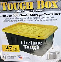 Close-up of product packaging label showing the "Tough Box" branding, product name "The Moving Tote", 27 gallon capacity, lifetime toughness, and Made in USA label.