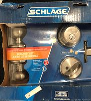 Front view of Schlage security set box showing the bright brass keyed entry knob, deadbolt, and package features.