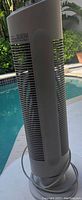 Full side view of the Ionic Breeze QUADRA Silent Air Purifier standing on the poolside patio.