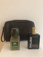 Photo showing English Leather lime-scented cologne bottle, Monsieur Houbigant musk after shave bottle, and black travel case, all in brand new condition.