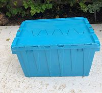 Front view of turquoise plastic storage container showing hinged lid and side details.