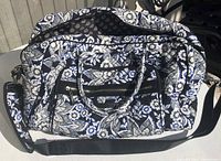 Front view of Vera Bradley large quilted travel tote showing floral pattern with black, white, and blue tones, with handles and shoulder strap visible.