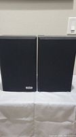 Pair of Bose Interaudio 2000 Series bookshelf speakers with black fabric grilles front view.