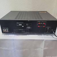 Rear view of Sony TA-AX301 stereo amplifier showing speaker terminals, RCA input/output connections, power cord, and ventilation grille on top.