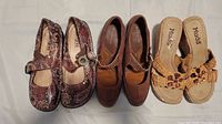 Photo showing three pairs of women's shoes: Alegria Mary Jane patterned shoes, brown leather Naturalizer loafers, and beige woven Mudd slip-on sandals with floral bead details.