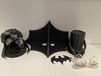 Full view of the Batman figure, shelf stand, logo cutout, and Batman light projector on table