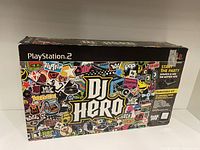 Front and top view of the DJ Hero PlayStation 2 box showing colorful artwork and branding.