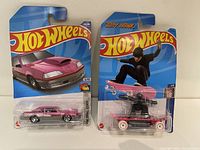 Two Hot Wheels new in package items, Tony Hawk skateboard figure and pink Ford Mustang car.