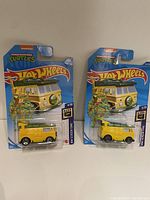 Two Hot Wheels Teenage Mutant Ninja Turtles yellow van die-cast cars in original packaging, front view showing TMNT artwork and logos.