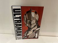 Front cover of Ultraman Volume 1 softcover novel featuring detailed character illustration on red background.