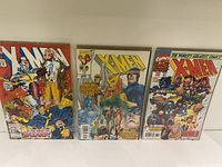 Front view of three X-Men comic books highlighting colorful, iconic Marvel cover art with worn edges