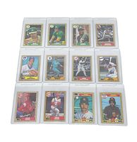 Overview of the 12 mint vintage baseball cards all in individual plastic protectors arranged in three rows of four, showing various players and managers mainly from 1980s Major League Baseball teams.