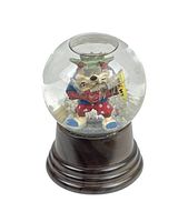 Front view of snow globe showing Tasmanian Devil figurine inside glass globe with Statue of Liberty crown and torch, mounted on dark wooden base.