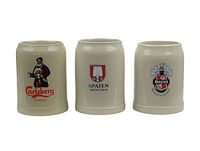Front view of three beige ceramic beer steins with Carlsberg, Spaten Munchen, and Beck's logos clearly visible.