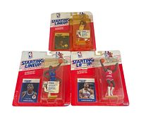 Lot of three NBA Starting Lineup figures visible in blister card packaging with some shelf wear.