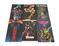 Six Image Comics trade paperback graphic novels laid out flat, titles include Hack/Slash, Monstress, Spawn, Krypto the Superdog, and Gladstone's School for World Conquerors.