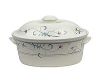 Front view of the oval serving bowl with painted floral design and lid with knob handle