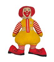 Front view of the vintage Ronald McDonald stuffed toy showing the character's red hair, red and white striped arms and legs, yellow vest with McDonald's logos, and large red shoes.