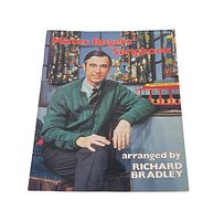 Front cover of the songbook showing Mister Rogers sitting and the title 'Mister Rogers Songbook' arranged by Richard Bradley.