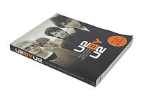 Front cover of 'U2 by U2' book showing band members and title.