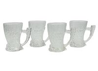 Four clear glass Flintstones embossed mugs shaped like mammoths with tusk-shaped handles, shown side by side