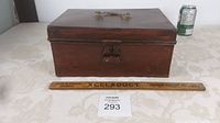 Closed antique metal document box front view with wooden ruler for scale
