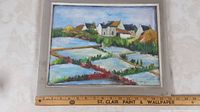 Full view of framed oil painting depicting a rural scene with houses and fenced water or field rows.