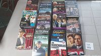 Photo showing the entire DVD lot arranged on the floor including titles: House of Cards, Wycliffe, Inspector Morse, Endeavour, Pie in the Sky, The Manchurian Candidate, Tropic Thunder, The Communicator, and others.