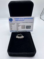 Ring displayed in a black velvet box with lab certificate propped behind it