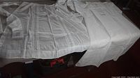 Long view of the whole set on a surface showing the length and shape of the dress and apron.