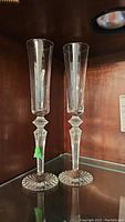 Pair of Baccarat crystal champagne flutes displayed on shelf