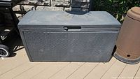 Overall closed view of the Keter outdoor deck box showing its rectangular shape, lid, and woven-like plastic texture.