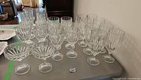 Photo of grouped clear crystal Mikasa wine glasses and two small pedestal bowls on a table, showing the Park Lane vertical etched pattern.