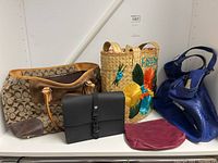 Wide shot showing five handbags on shelf