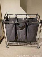 Front and angled views of 3-bag dark grey fabric laundry sorter cart on chrome metal frame with wheels
