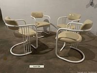 Four cantilever chairs arranged in a circle on concrete floor