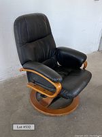 Front left three-quarter view showing overall shape, wood base and leather upholstery