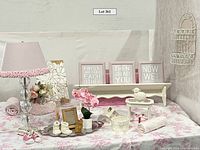Overview of the lot contents including lamp, curtains, framed decor, silver tray with baby items, and floral decor