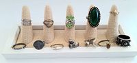 Lot of 12 vintage cocktail rings displayed on a beige ring holder tray with some rings featuring colorful stones and coin design.