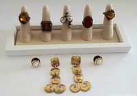Front view of the 9 piece vintage jewelry lot including rings on display cones and earrings laid out in front.