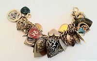 Full photo of chunky charm bracelet showing multiple heart-shaped charms and other decorative charms on a gold-tone chain.
