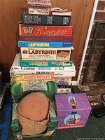 Stack of board games and Couch Potato novelty toy in a green armchair