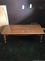 Full view of rectangular wooden coffee table showing top surface and leg design.
