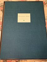 Blue hardcover portfolio with a label reading Grandma Moses affixed to the front cover