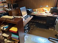 Wide view of desk holding HP Envy 7645 printer, computer monitor, keyboard, file sorter with paper, desk lamp, and other office supplies